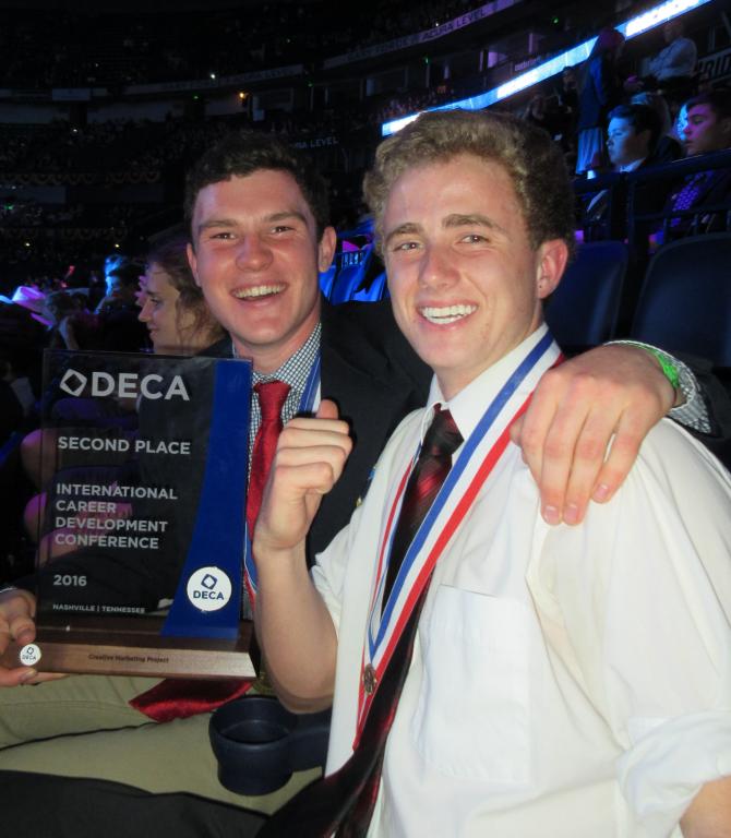 Students holding DECA award.